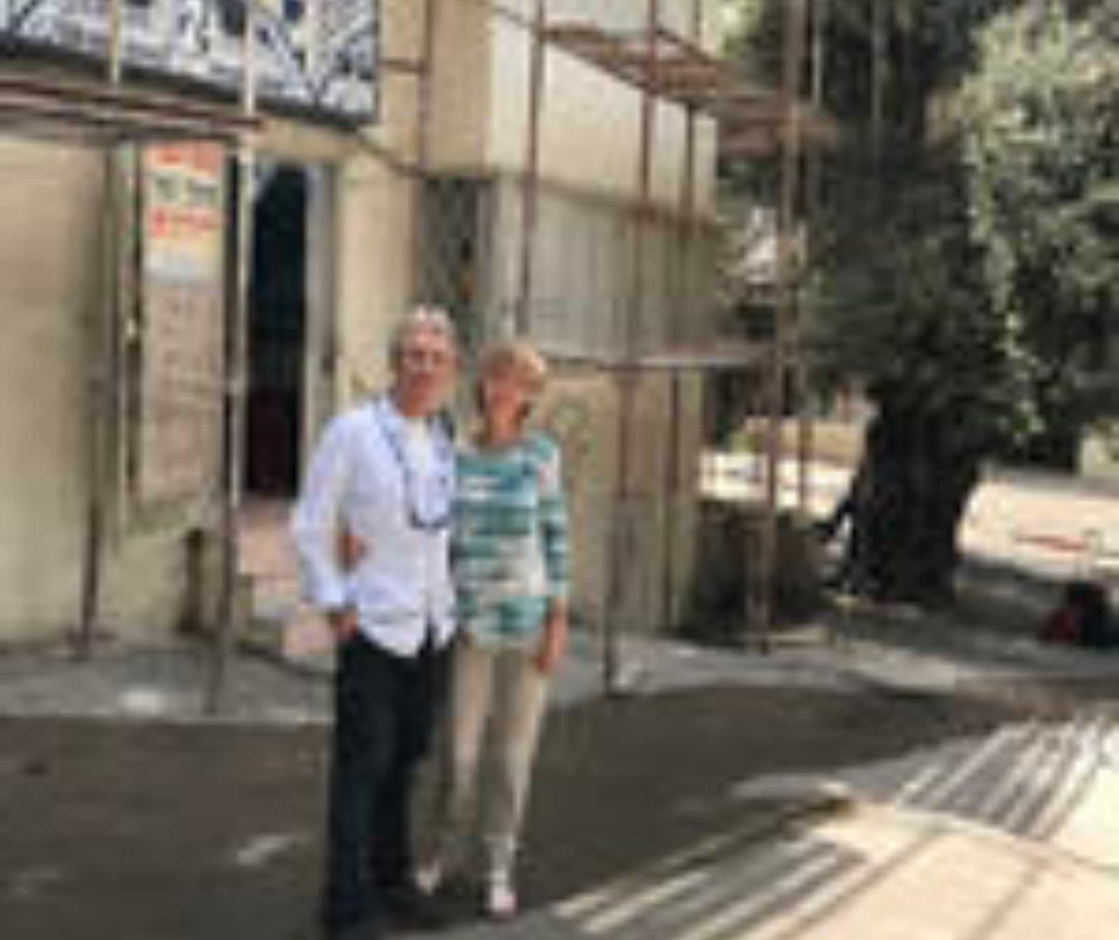 eine Frau und ein Mann vor einem Gebäude mit Gerüst