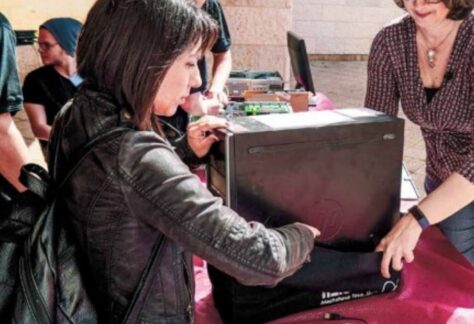 zwei Frauen packen einen Rechner in eine Tasche