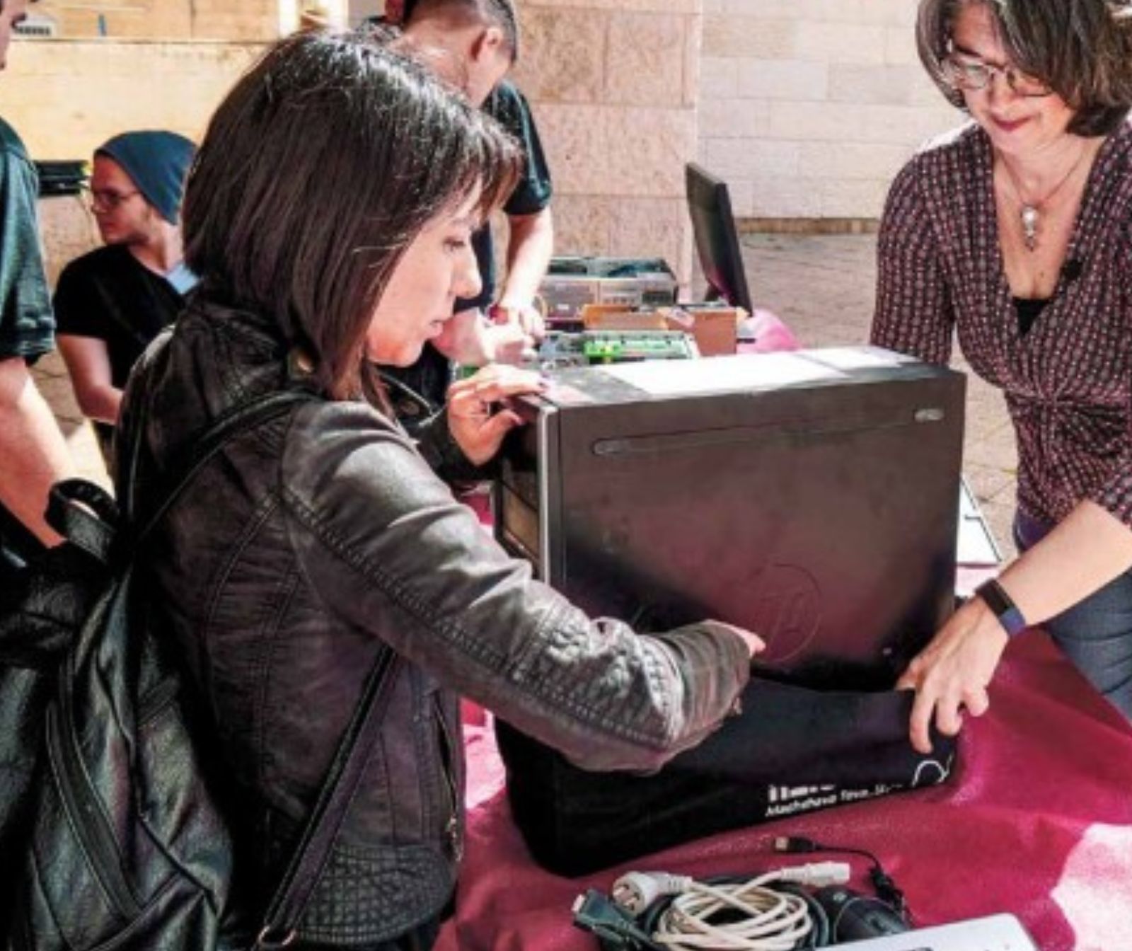 zwei Frauen packen einen Rechner in eine Tasche