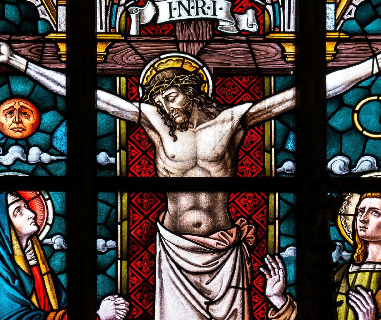 Ein Buntglasfenster in einer Kirche zeigt die Kreuzigung Jesu