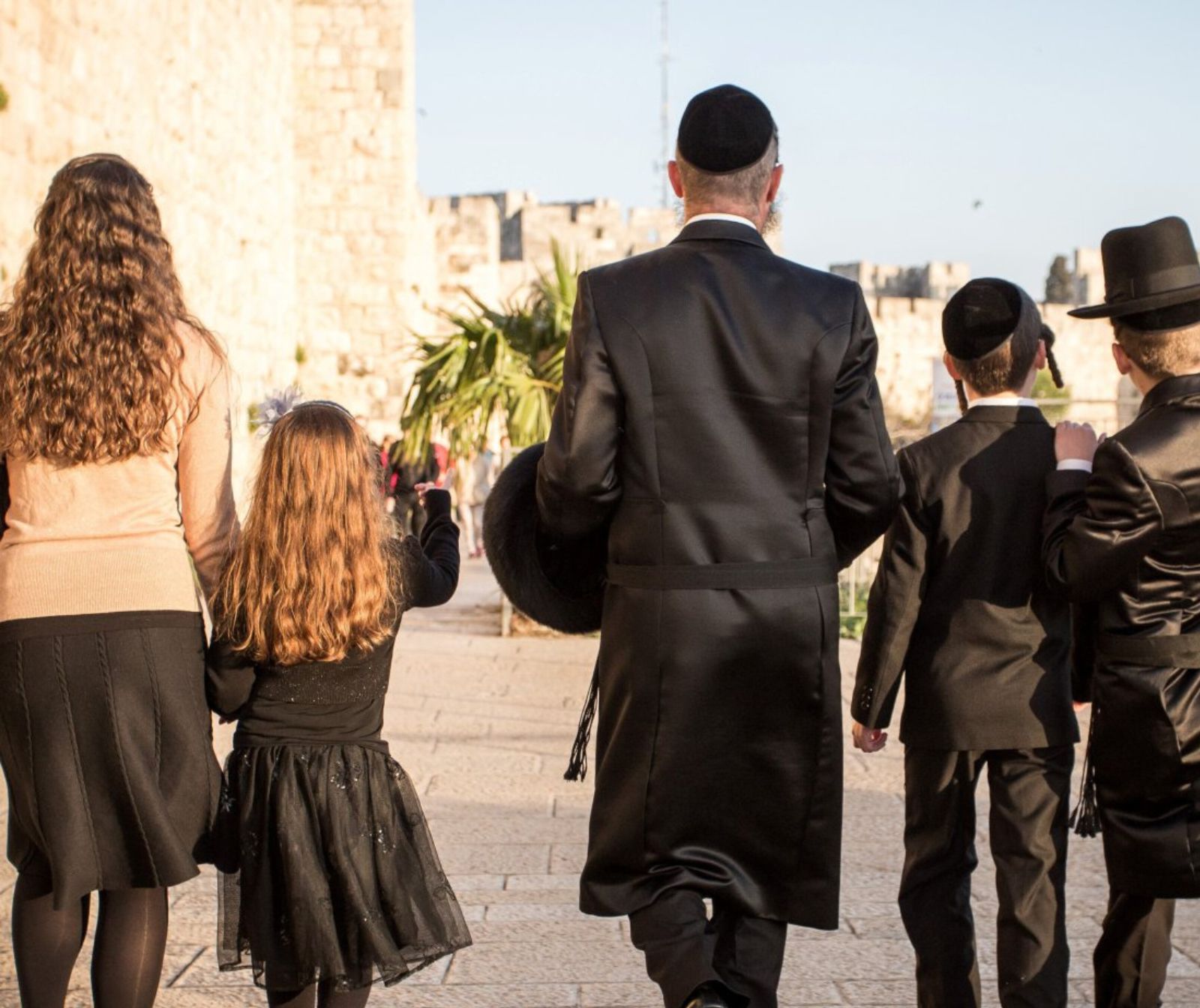 Links im Bild läuft eine Frau, an der Hand hält sie ein Mädchen. Rechts im Bild läuft ein Mann, neben ihm zwei Jungen.