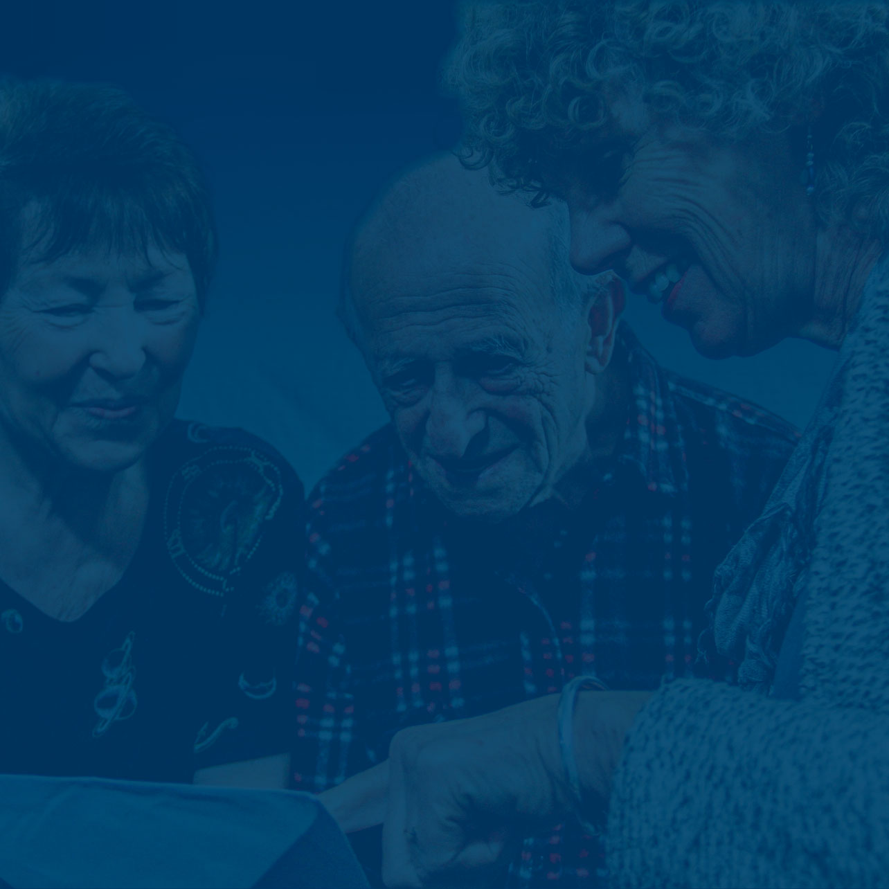 Holocaust überlebendes Rentnerpaar wird von einer Frau beraten die auf ein Dokument zeigt