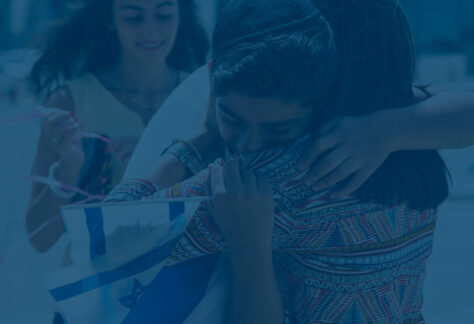 Jüdischer Junge umarmt seine Mutter mit einer kleinen Israel Fahne in der Hand