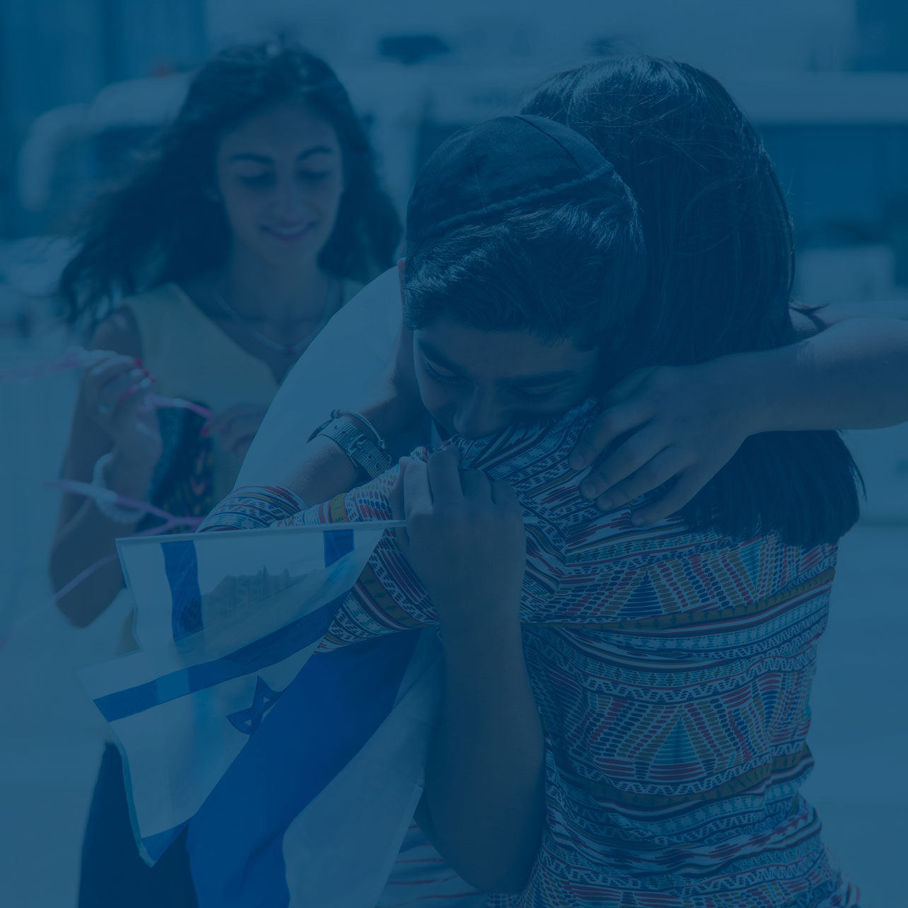 Jüdischer Junge umarmt seine Mutter mit einer kleinen Israel Fahne in der Hand