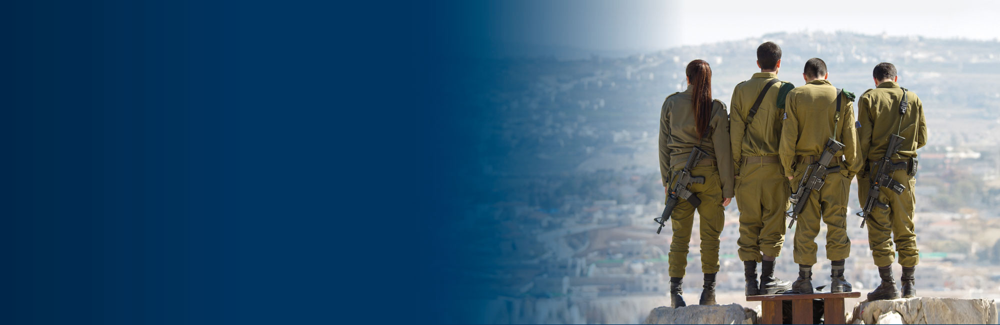 Israelische Soldaten und Soldatinnen stehen vereint auf einer Anhöhe und schauen auf Ihr Land