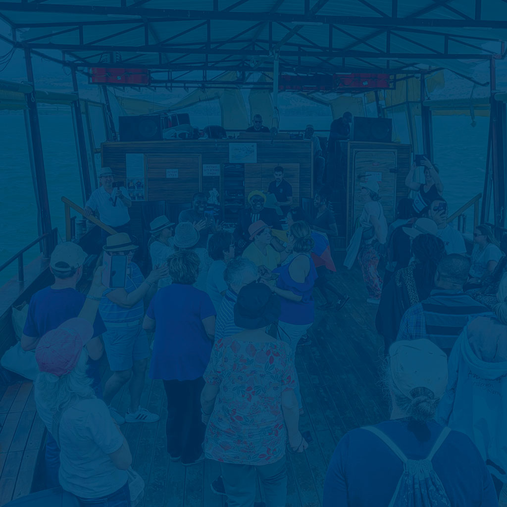 Personen tanzen auf einem Schiff auf Deck und sind dabei sehr Glücklich