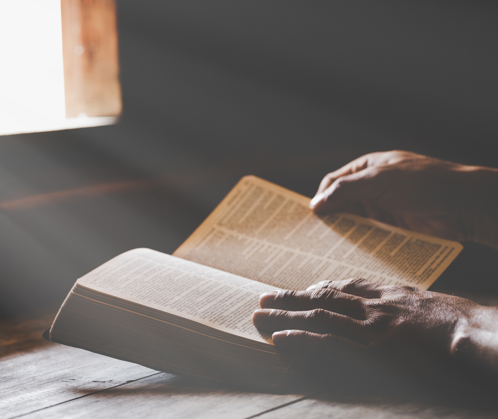 zwei Hände beim aufschlagen einer Bibel