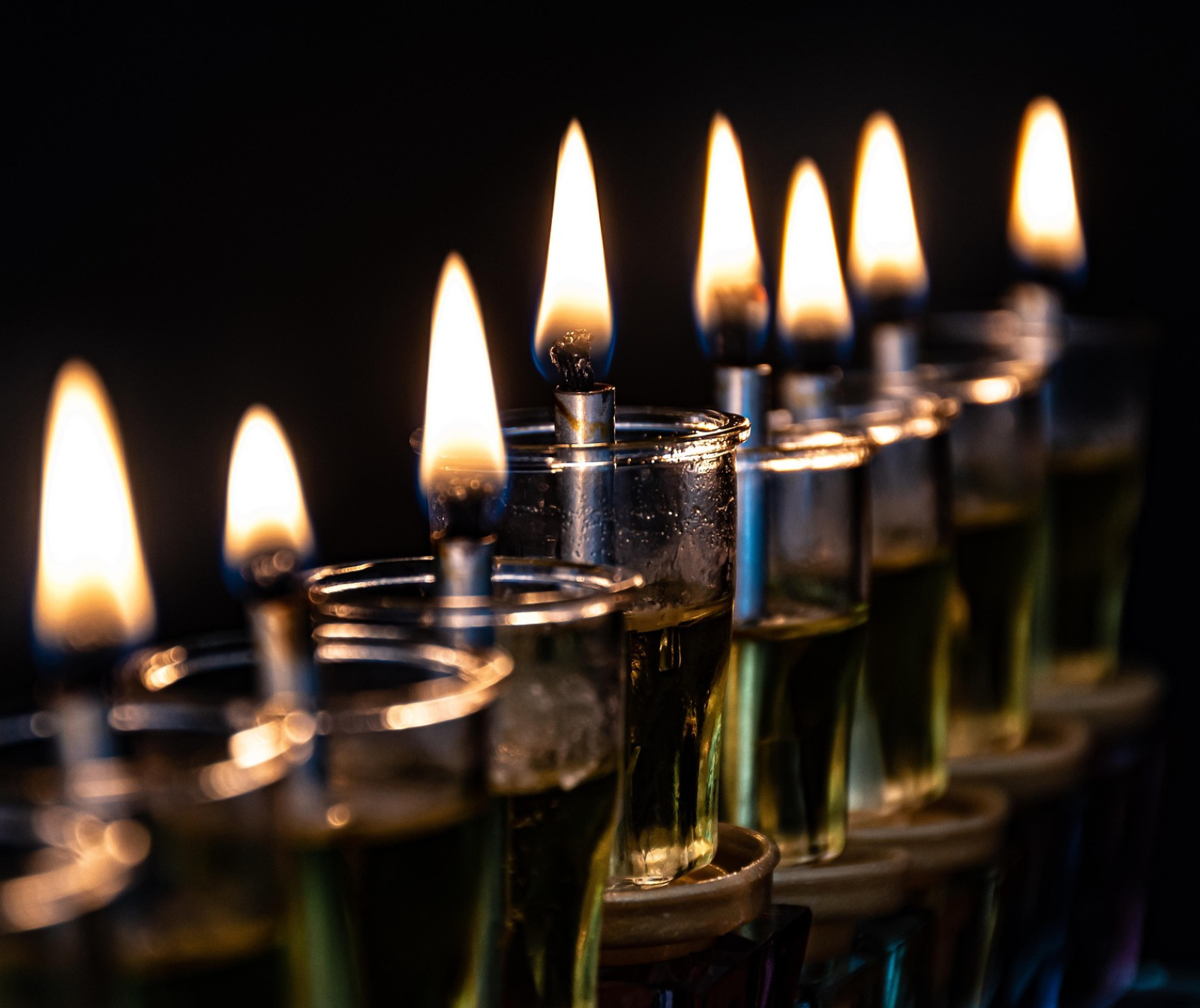 Mehrere Öllampchen brennen auf einer Chanukkia