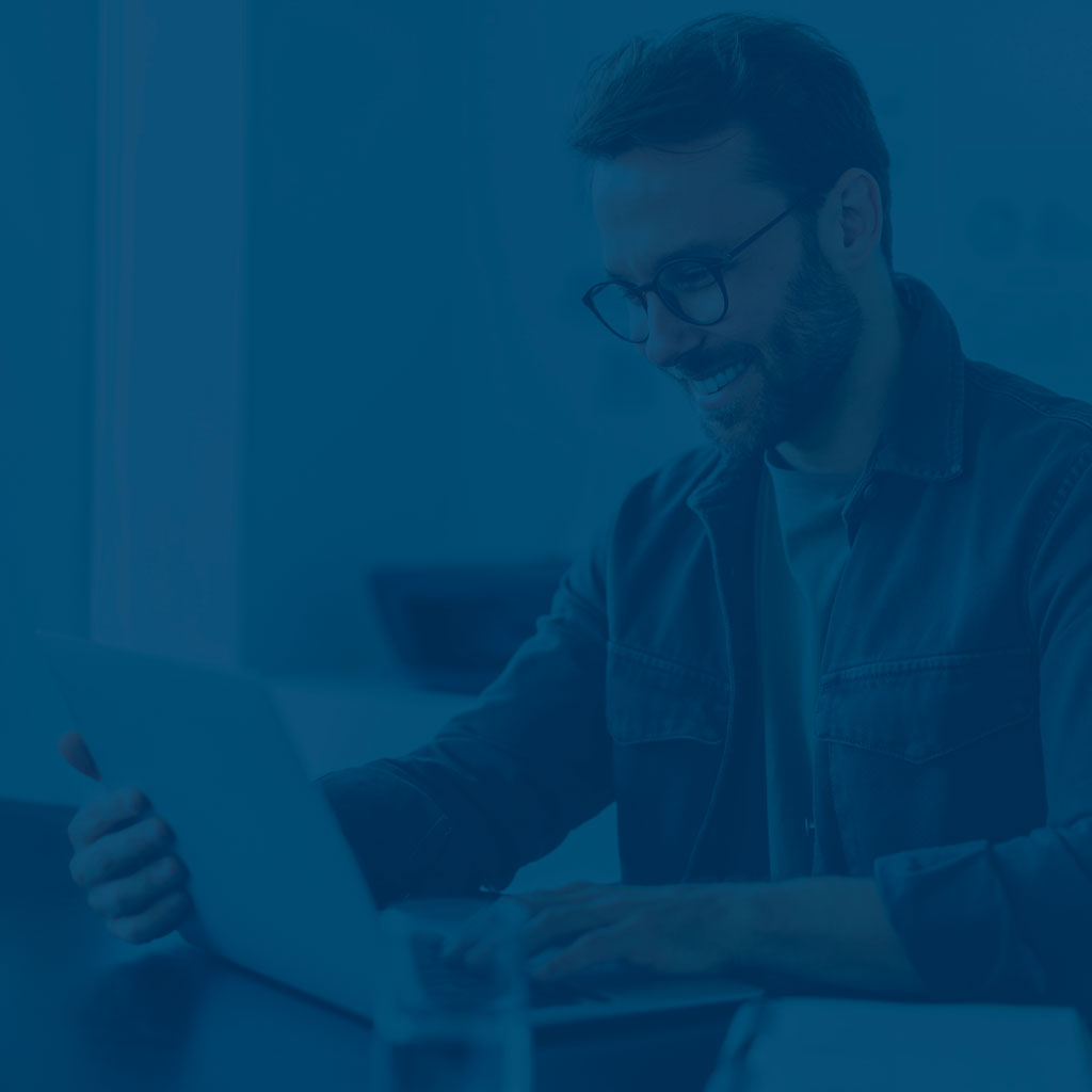 Mann öffnet ein Laptop und freut sich