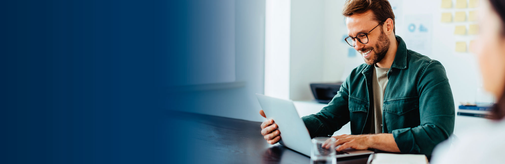 Mann öffnet ein Laptop und freut sich