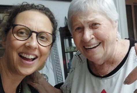 eine jüngere und eine ältere Frau lächeln herzlich in die Kamera