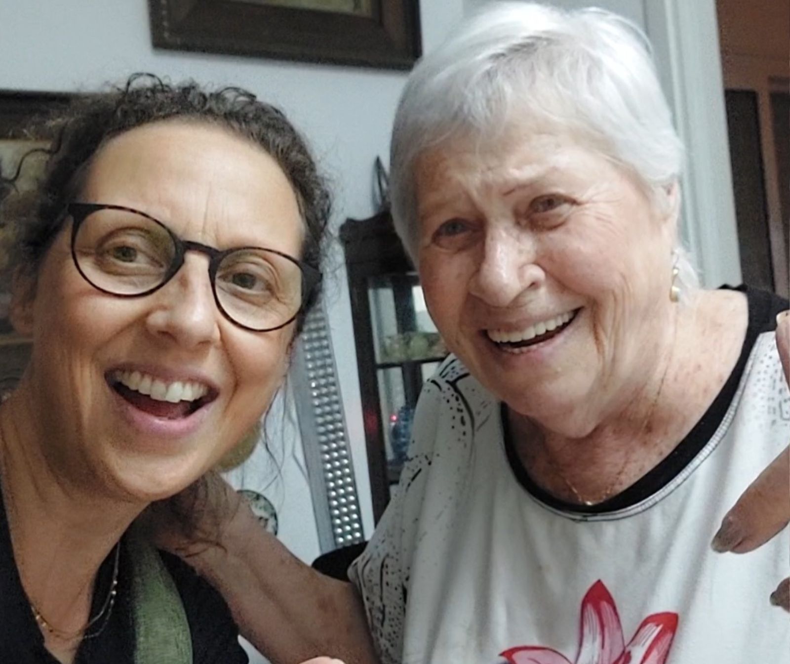 eine jüngere und eine ältere Frau lächeln herzlich in die Kamera