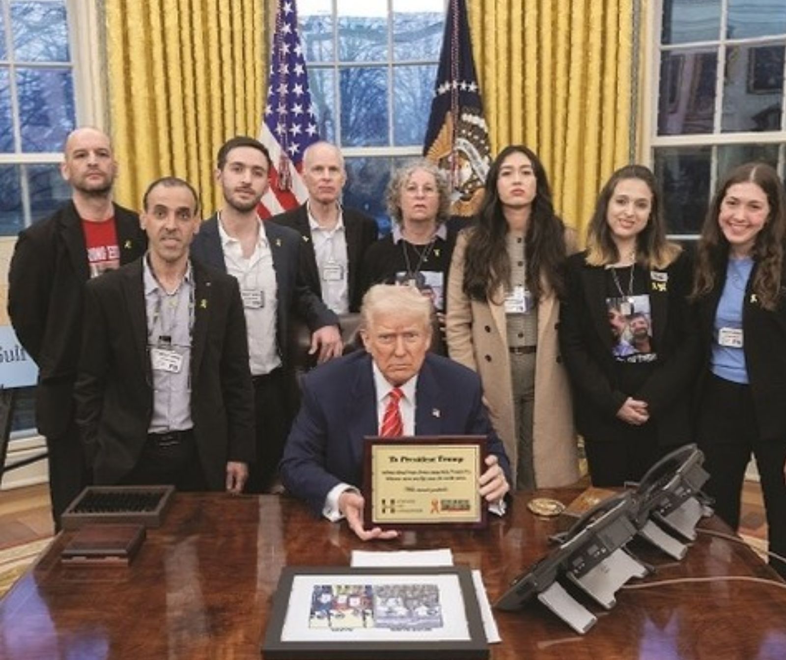 Trumps 20-Punkte-Plan – wichtige Eckdaten - President Trump am tisch mit Dokument in der Hand. Hinter ihm stehen eine Gruppe Menschen, alle schauen in die Kamera