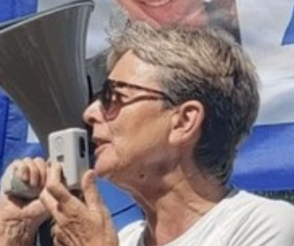 Tote Geisel: Leichen-Übergabe nach elf Jahren - eine ältere Frau mit Sonnenbrille spricht in ein Megafon