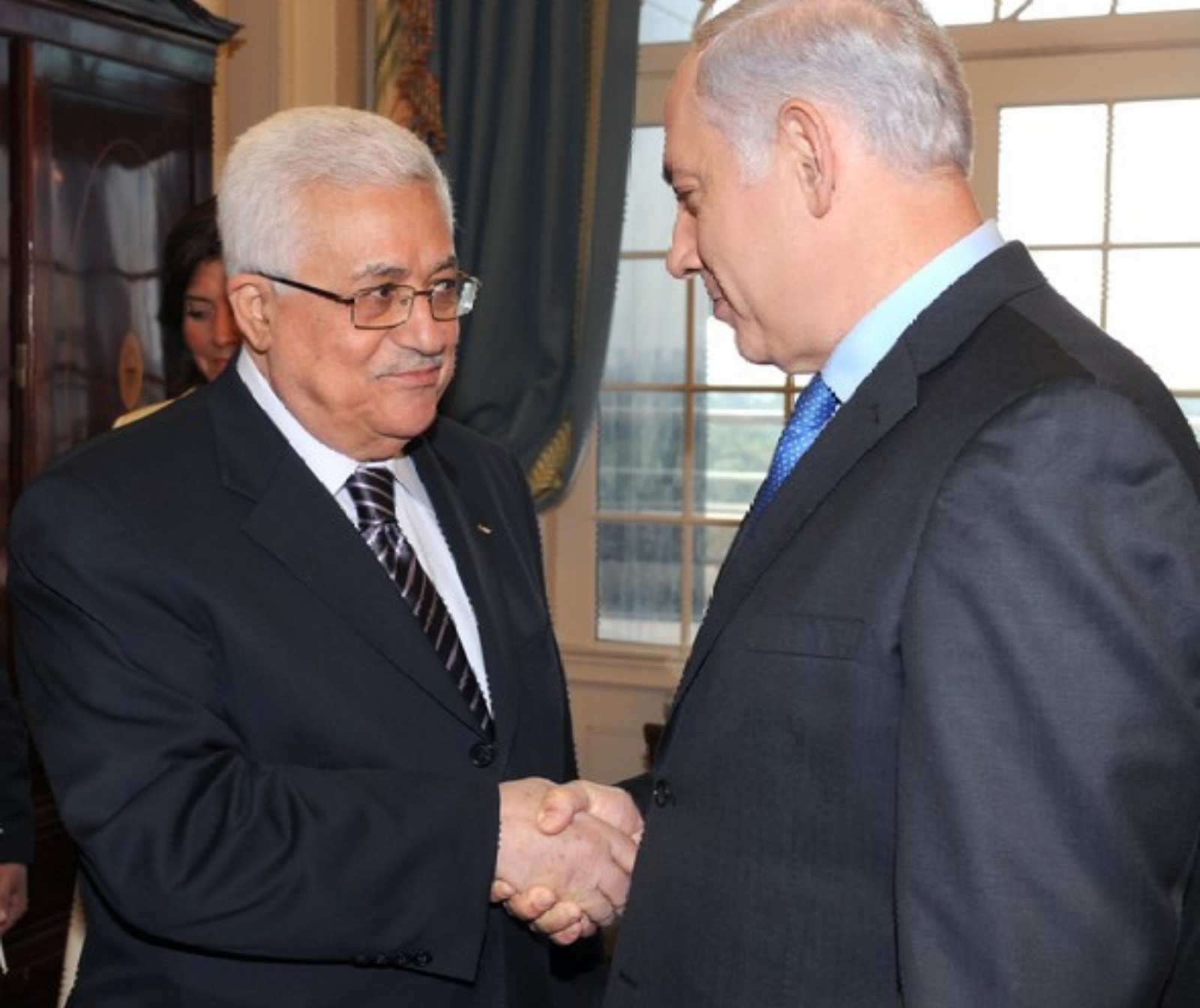 zwei älteren herren in feinen Anzügen schütteln sich die Hände und schauen sich in die Augen