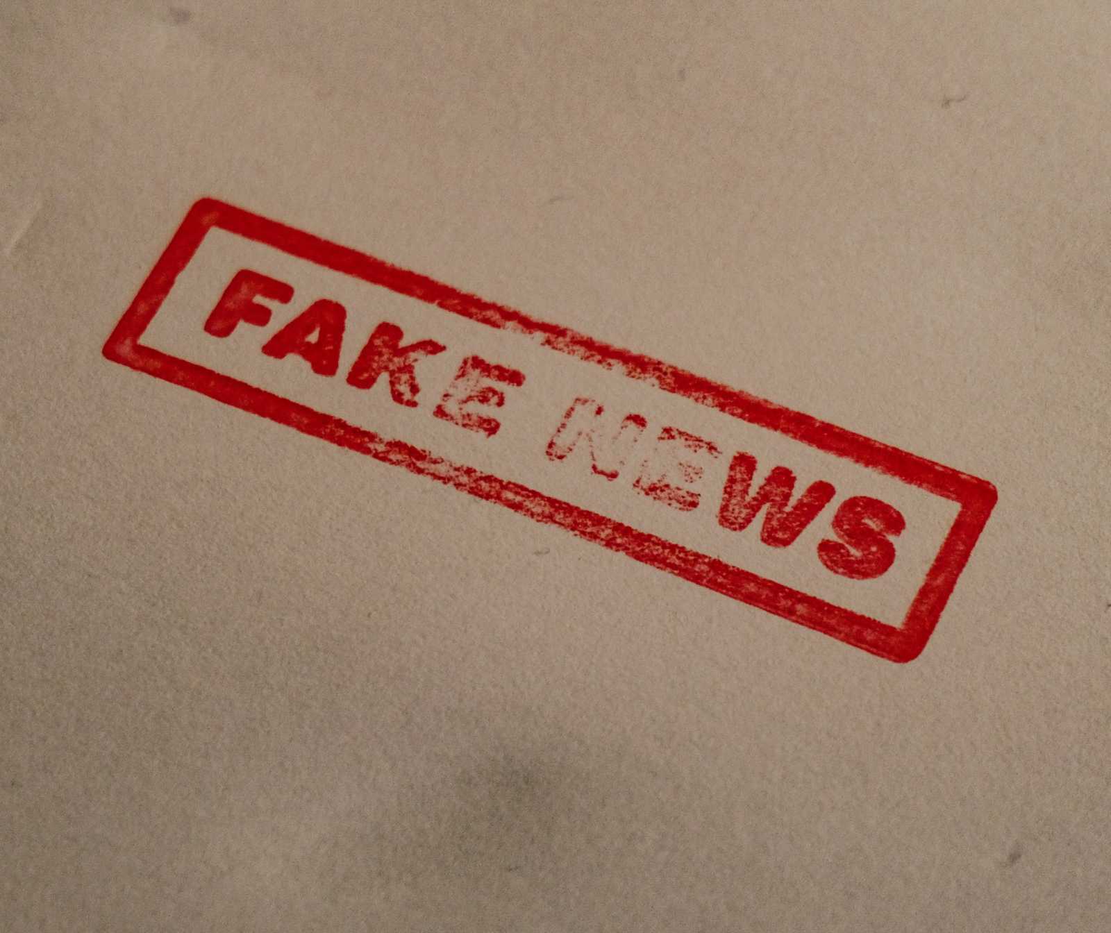 Roter Schriftzug in Stempel Art: Fake News