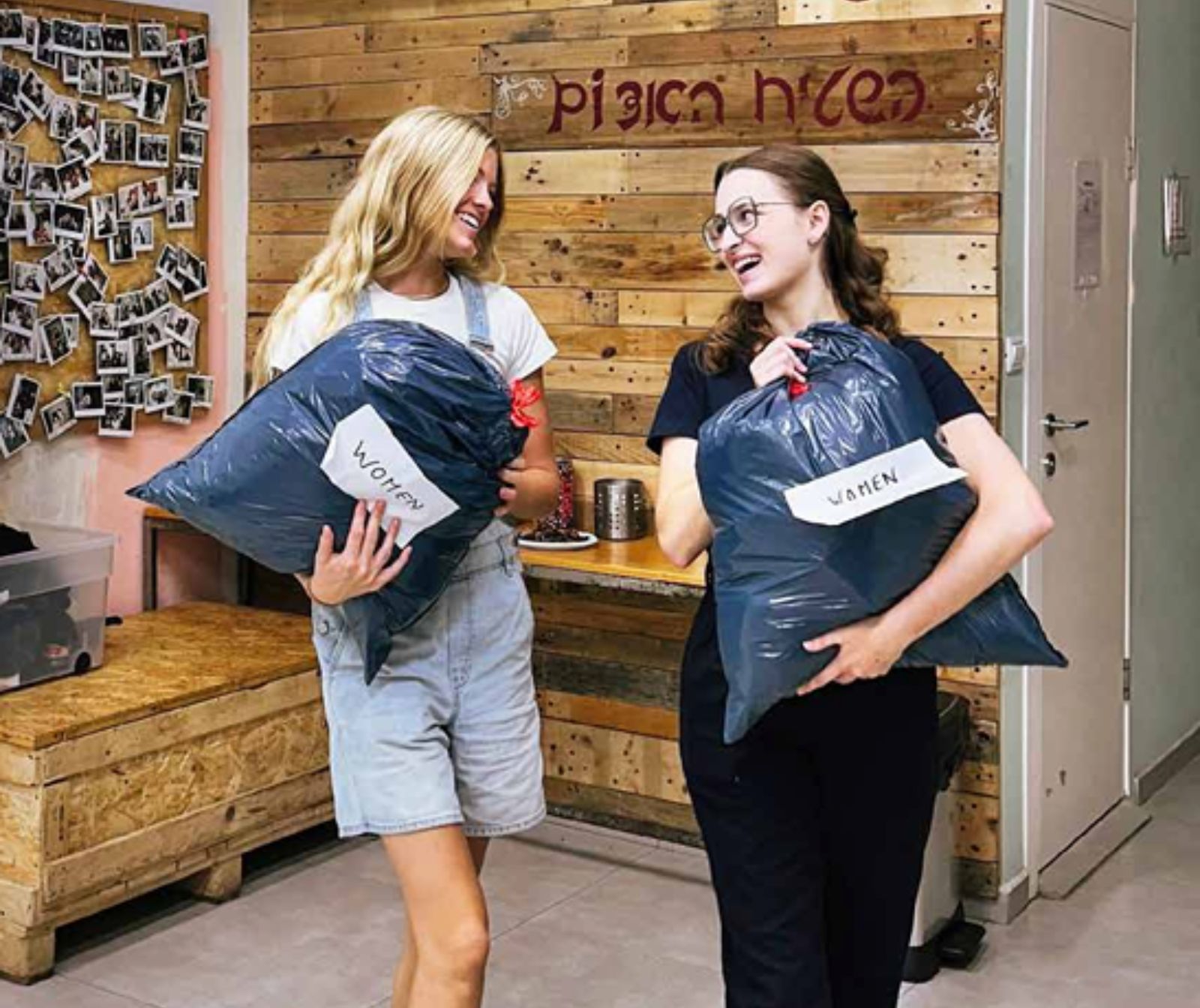 Zwei Frauen unterhalten sich und halten dabei jeweils einen schwarze, vollen Plastiksack in der Hand