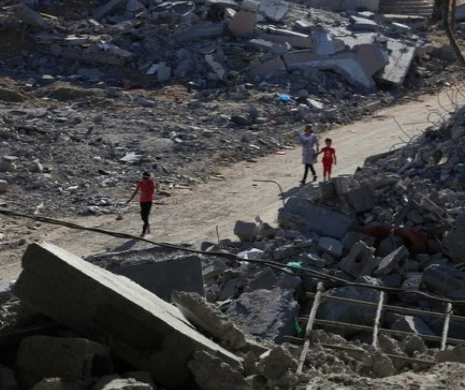 Zivilisten, darunter ein kind, laufen durch ein Gebiet mit Gebäudetrümmern