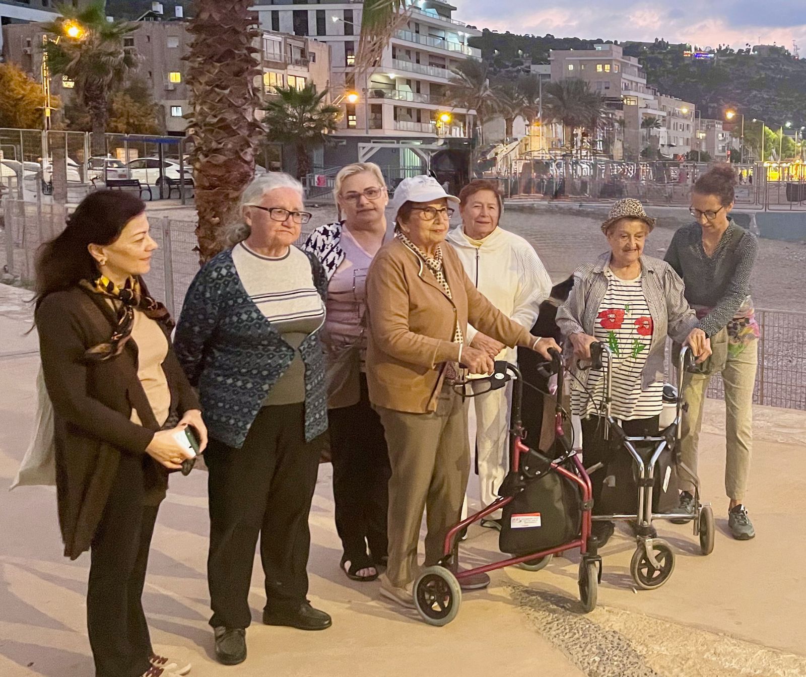 sieben Frauen, darunter einige ältere Damen, an einer Strandpromenade