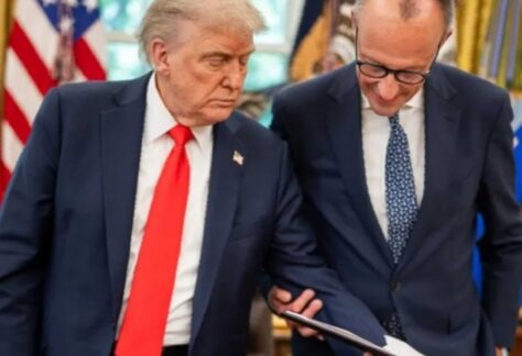 zwei Männer mit blauem Anzug schauen in eine aufgeschlagene Mappe. Der eine trägt eine rote, der andere eine blaue Krawatte