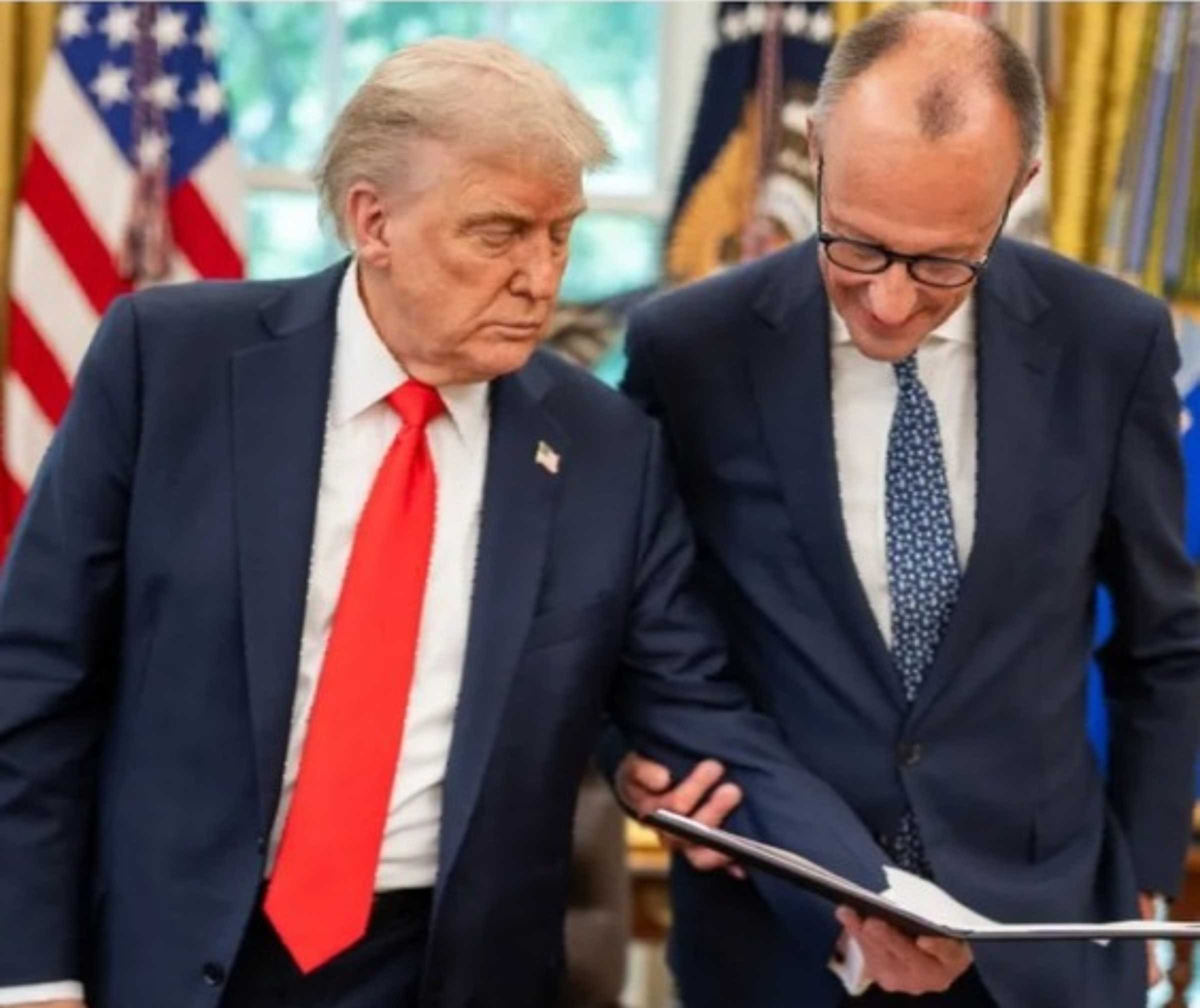 zwei Männer mit blauem Anzug schauen in eine aufgeschlagene Mappe. Der eine trägt eine rote, der andere eine blaue Krawatte