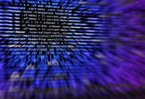 verschwommen dargestellter Programmcode in weiß auf blauem Hintergrund