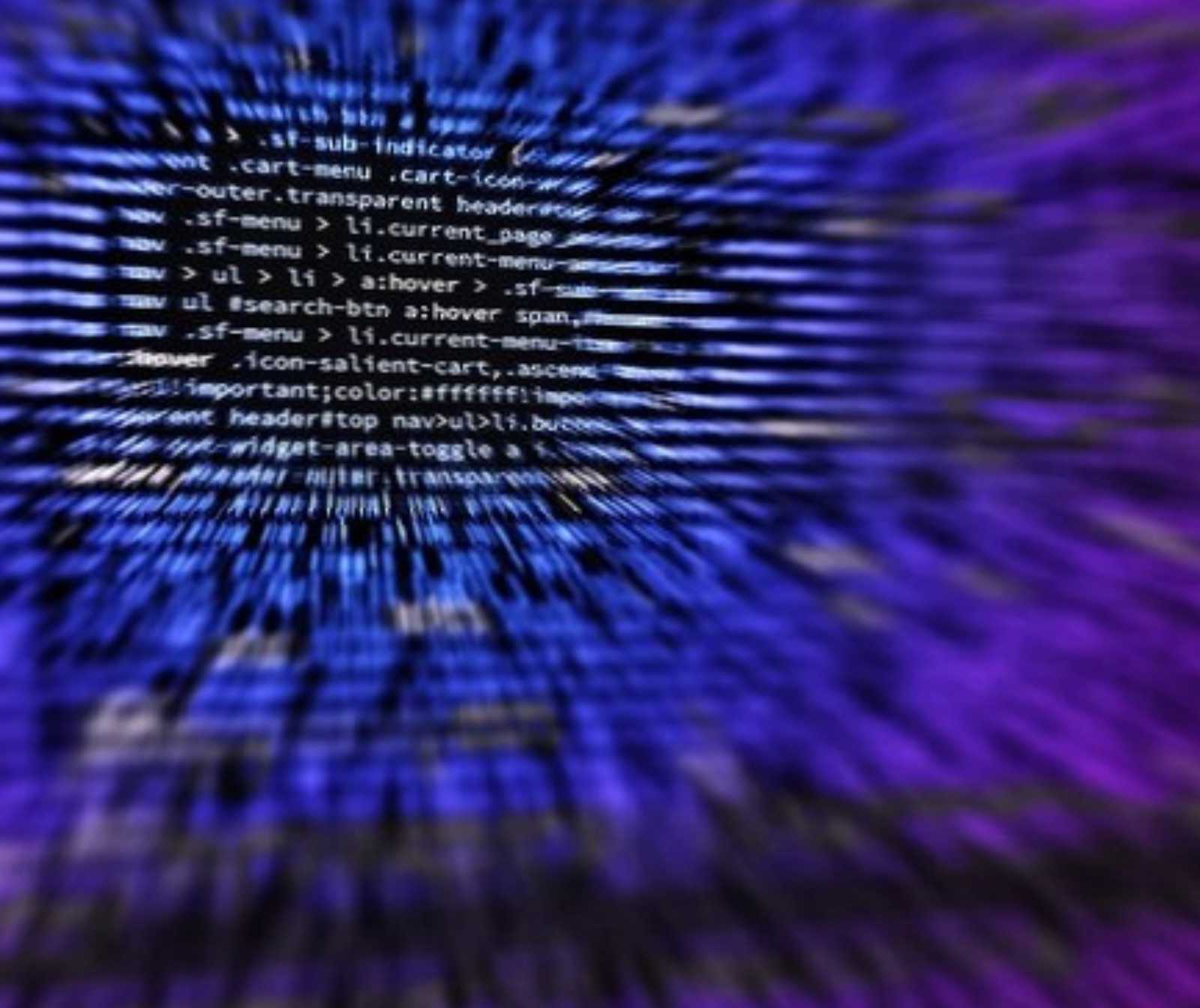 verschwommen dargestellter Programmcode in weiß auf blauem Hintergrund