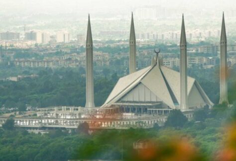 Luftansicht einer Großstadt. Eine große Moschee mit vier Minaretten im Vordergrund