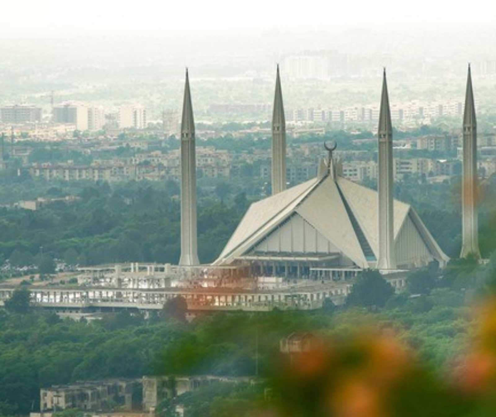 Luftansicht einer Großstadt. Eine große Moschee mit vier Minaretten im Vordergrund