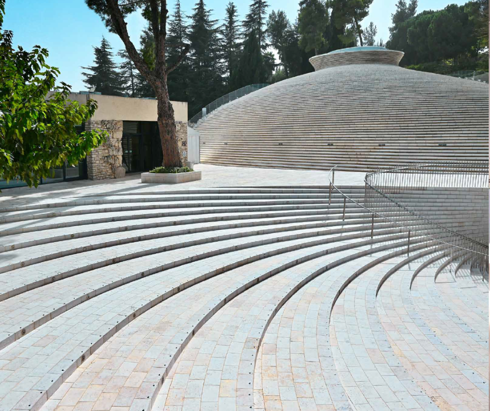 eine Anlage im Freien mit großen Treppen und einem anliegenden Gebäude mit treppenartiger Fassade. Im Hintergrund sind Bäume zu sehen.