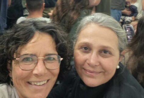 Selfie zweier Frauen. Sie lächeln; im Hintergrund sind weitere Menschen zu sehen, einer trägt eine Kippa